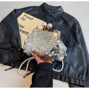 Detailed view of silver sequin evening bag with pearl bead handles and golden clasp lock