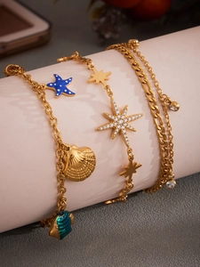 Detaillierte Nahaufnahme des goldenen Ozean-Armbands mit Seestern-, Muschel- und Sternanhängern