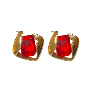 Golden geometric earrings with a rectangular red gemstone in a vintage liquid metal design
