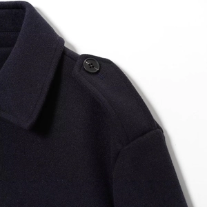 Manteau en laine bleu marine avec col à revers et épaulette sur fond blanc minimaliste