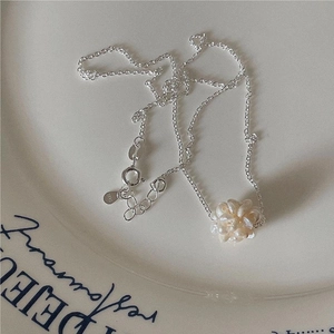 Elegant S925 sterling silver necklace featuring a pearl flower pendant on a ceramic dish