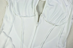 Detailed view of a white structured corset top with central zipper and visible seams