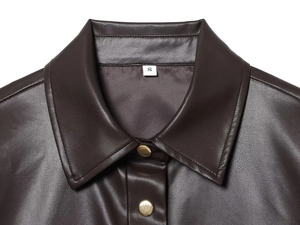 Détail de la veste en similicuir marron foncé avec boutons métalliques et coutures du col