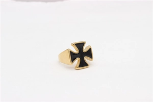 Macro detail of men's gold and black enamel Maltese cross ring in polished steel
