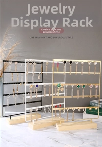 Three-piece metal jewelry stands in black, white, and gold with solid wooden bases