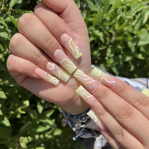 Long pink gradient press-on nails with white wave patterns and blue rhinestones