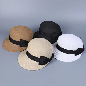 Dettaglio di cappelli di paglia con fiocco nero in quattro tonalità estive