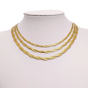 Detailed view of triple-layered gold stainless steel snake chain necklace on white model