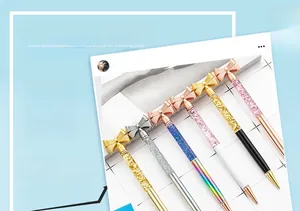 Detail of six bow-topped ballpoint pens featuring glitter oil sand filled metal barrels