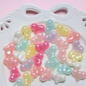 Close-up of heart-shaped pearlescent resin beads for DIY jewelry making on a white tray