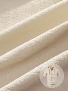 Gros plan sur la texture du tissu en coton beige et les détails du chemisier à capuche