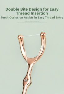 Detail view of a rose gold Y-shaped stainless steel dental floss holder on mint background