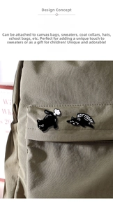 Détail de pins chat noir en émail avec texte Not Today sur un sac en toile grise