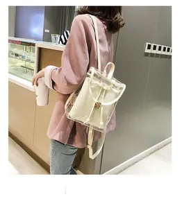 Detail view of transparent PVC backpack with white drawstring inner bag and metal buckle