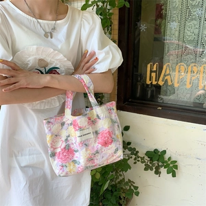 Gros plan du sac en toile au motif floral vintage avec étiquette de logo brodée