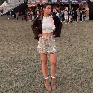 Outdoor-Look mit funkelndem silbernem Paillettenrock in A-Linie und brauner Jacke