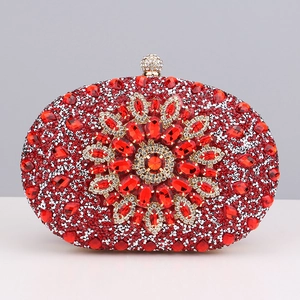 Detailed view of red rhinestone evening clutch with central gemstone floral pattern