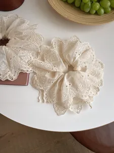 Detailed view of beige lace embroidery scrunchies with elegant floral hollow patterns