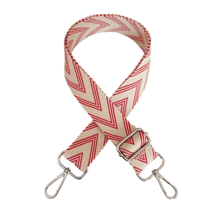 Detail of red and beige geometric woven canvas shoulder strap with silver metal hooks