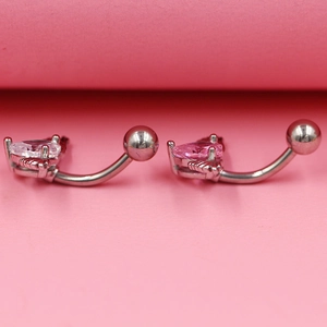 Gros plan de piercings de nombril en forme de cœur avec ailes en rose et blanc