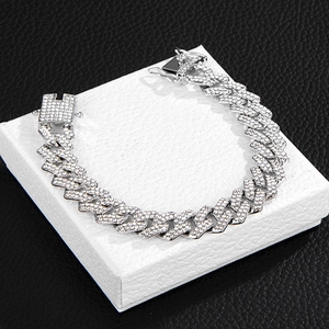 Detail of silver Cuban link bracelet with pavé rhinestones on a white gift box