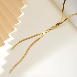 Detail of golden snake bone chain necklace with metallic texture on white background