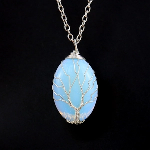 Detail of silver wire-wrapped tree of life pendant with opalite gemstone on black background