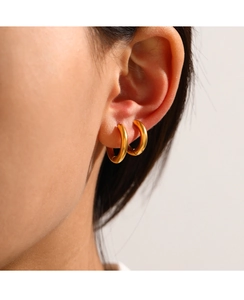 Detailed view of gold minimalist geometric round stud earrings in polished stainless steel