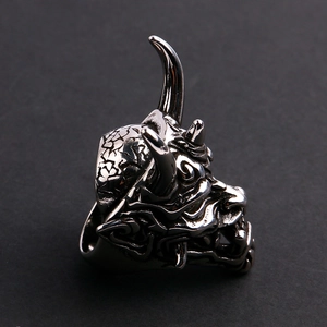 Macro view of stainless steel oni mask ring featuring intricate demonic carvings and details