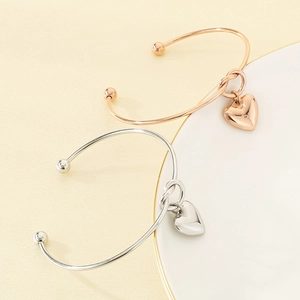 Gros plan de bracelets nœuds en forme de cœur en finitions or rose poli et argenté