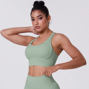 Detail view of crisscross back sports bra and high waist leggings in sage green