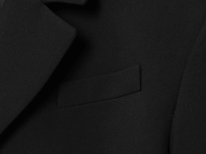 Vue macro du revers d'un blazer noir et des coutures de précision sur la poche poitrine