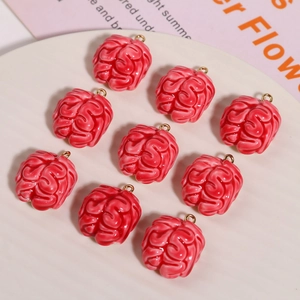 Nine creative red resin brain charms with gold loops on a white round ceramic plate
