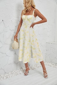 Detail of white floral sundress featuring side slit and elegant yellow flower print