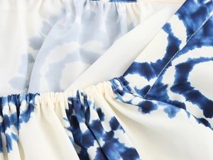 Detailed close-up of blue and white tie-dye fabric featuring shirring pleat texture