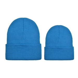 Detail view of bright blue knitted beanies showing adult and child sizes in soft fabric