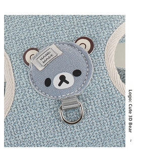 Detail of blue woven pet harness featuring a cute bear patch and metal D-ring hook