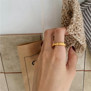 Minimalist 925 sterling silver knotted ring with gold texture shown from 45-degree angle