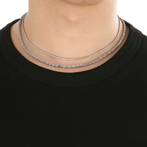 Detail of layered silver rope and snake chains on model neck for minimalist style