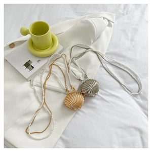 Detail view of shell-shaped evening bags with pearl chains in gold and silver finishes