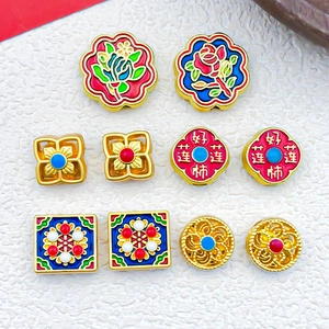 Detaillierte Makroansicht von Sandgold-Anhängern mit Emaille-Lotus und Pfirsich-Motiven