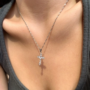 Macro detail of S925 sterling silver cross pendant necklace with sparkling cubic zirconia