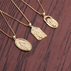 Detailed view of three gold plated Virgin Mary necklaces on dark wood surface
