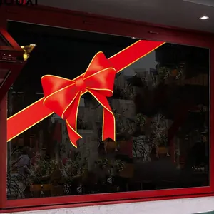 Detail of red bow Christmas window sticker with gold Merry Christmas lettering