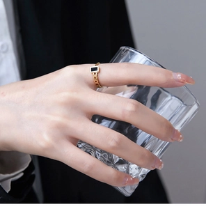 Macro shot of 18K gold plated chain ring with black square stone inlay on finger