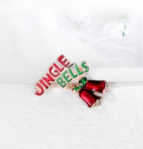 Detail of colorful JINGLE BELLS brooch with red enamel bells and green lettering
