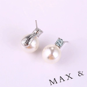 Detail view of pearl stud earrings featuring square cut cubic zirconia and silver finish