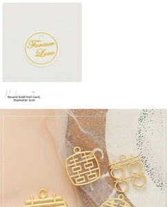 Macro detail of golden Double Happiness metal charms and Forever Love cards for DIY wedding decor