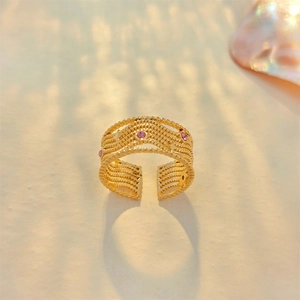 Detail of adjustable gold ring with multi-row twisted texture and pink gemstones
