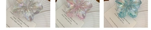 Detailed view of three colorful frangipani flower hair claws in white pink and blue